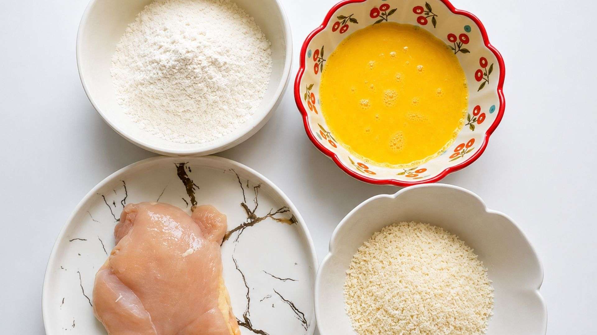 Chuẩn bị ức gà, bột mì, trứng và bột chiên xù để sơ chế, ướp và áo bột cho gà.