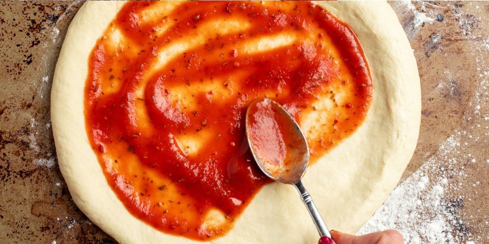Rã đông đế pizza và phết xốt vừa đủ giúp bánh hương vị khi nướng.chín đều, giữ được độ giòn và cân bằng 