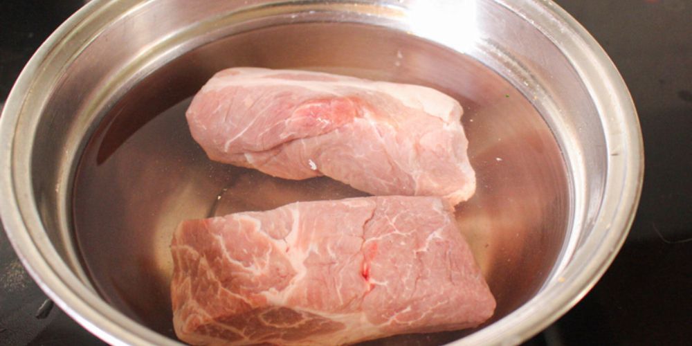 Rửa sạch thịt heo với nước muối loãng