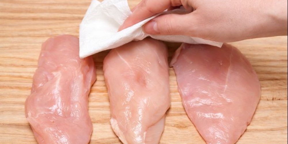 Thấm khô ức gà giúp bột bám đều và không bong tróc