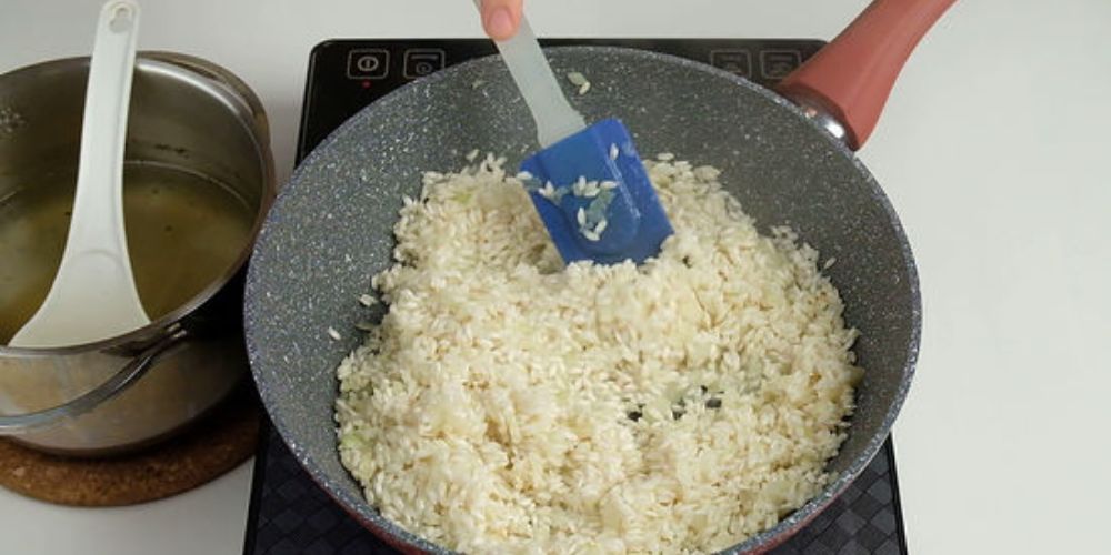 Đảo gạo trên chảo để hạt trong lại và giữ form khi nấu risotto