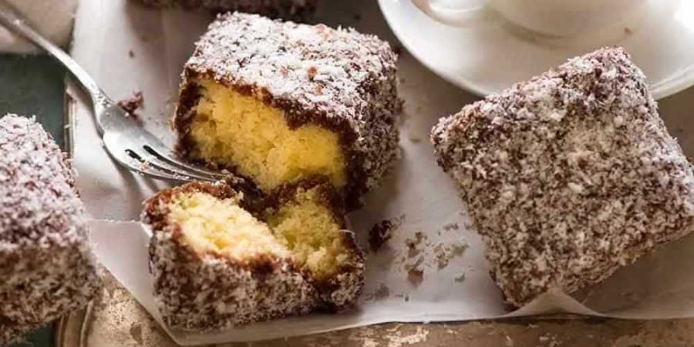 Bánh Lamington phủ socola và dừa sấy, kết cấu nhẹ và vị ngọt vừa.