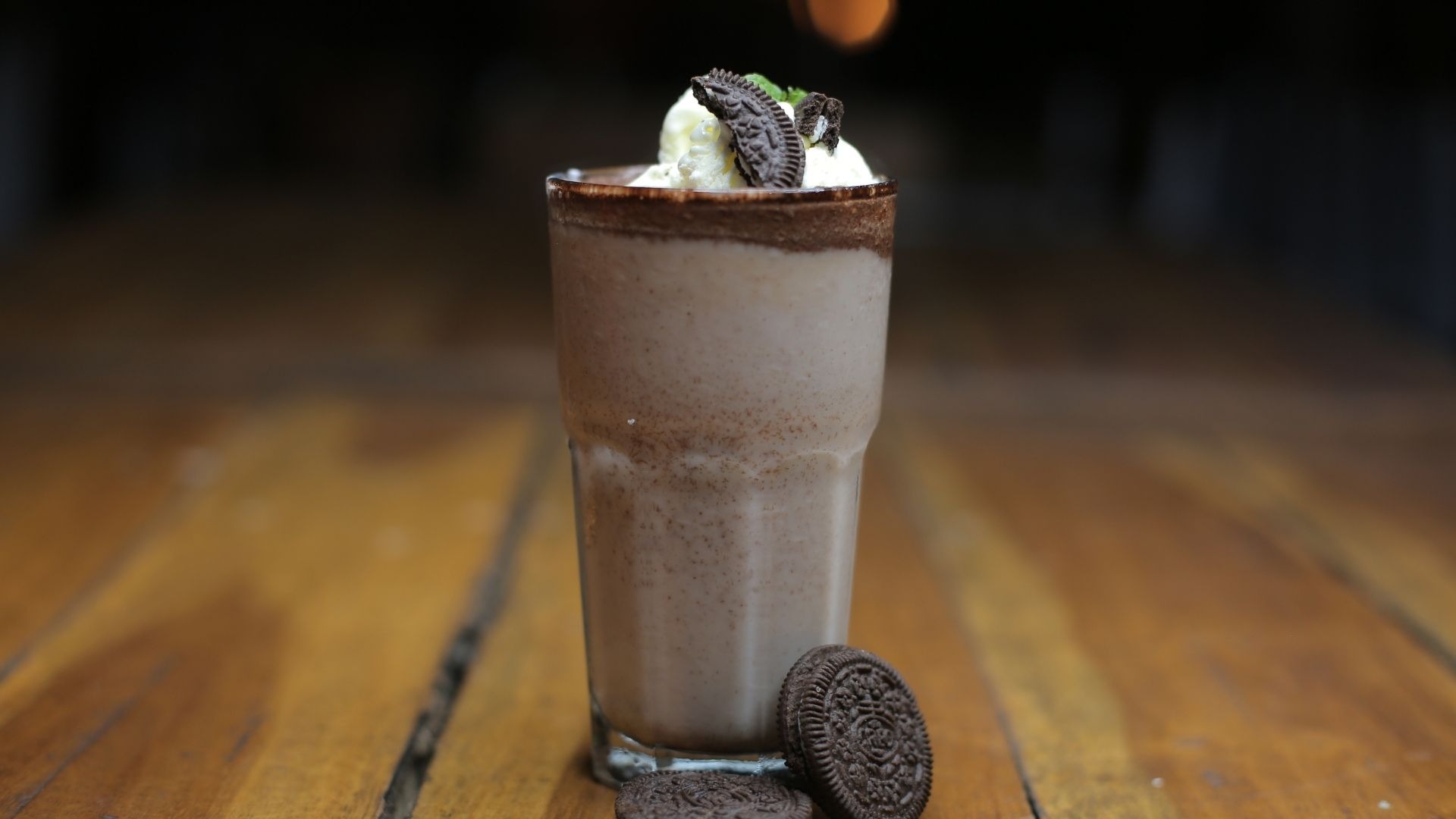 Hoàn thiện ly oreo đá xay với kem tươi, xốt chocolate và bánh Oreo để tăng thêm hương vị và tính thẩm mỹ