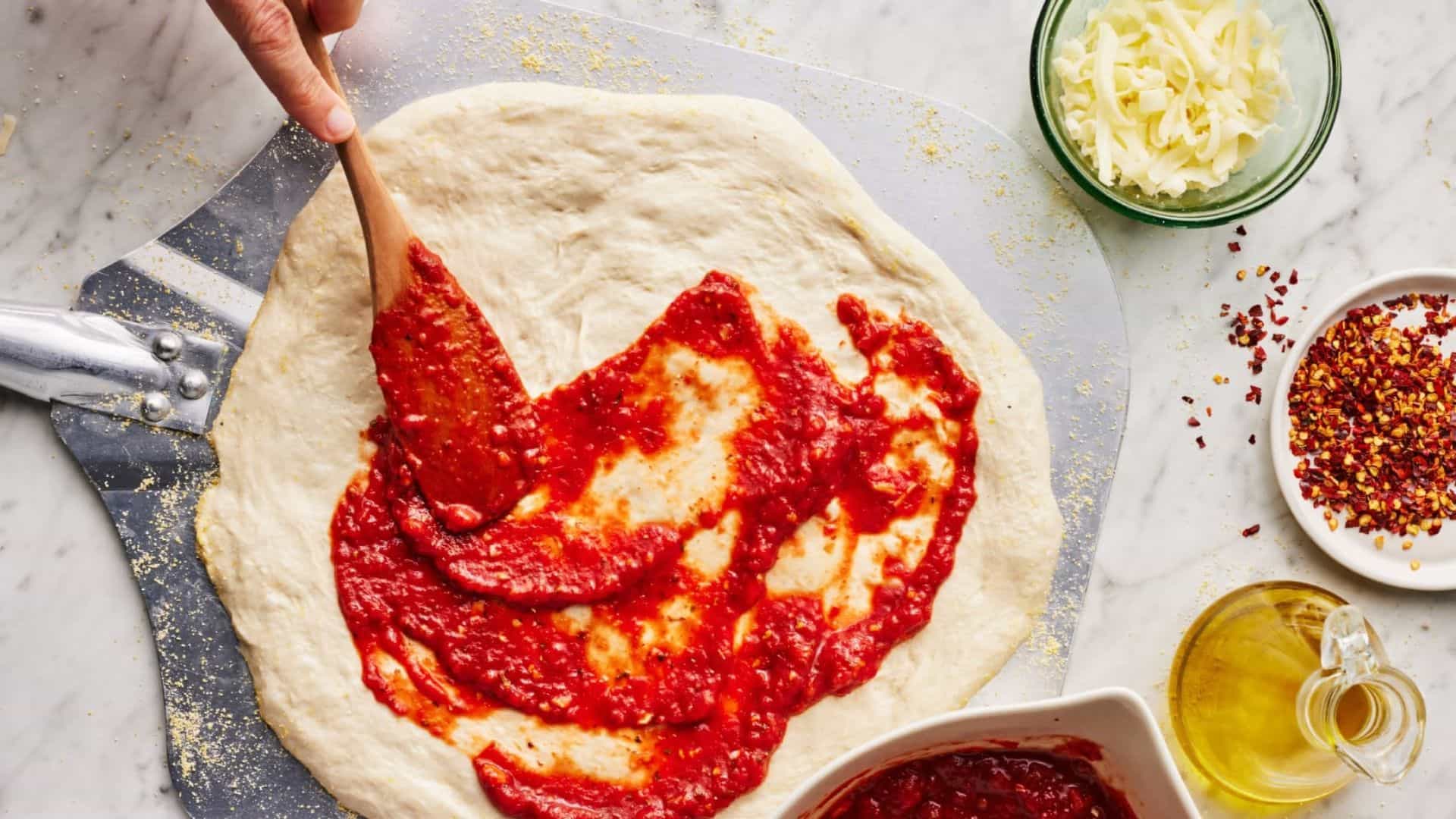 Tạo hình đế pizza tròn, phết xốt cà chua vừa đủ
