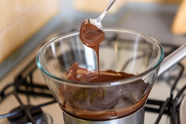 Đun sữa với socola trên lửa nhỏ, khuấy đều đến khi hỗn hợp mịn mượt