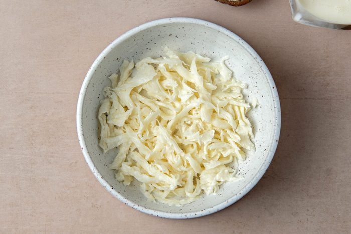 Phô mai Mozzarella được xé nhỏ để chuẩn bị cho phần nhân Stracciatella mềm mịn của Burrata.