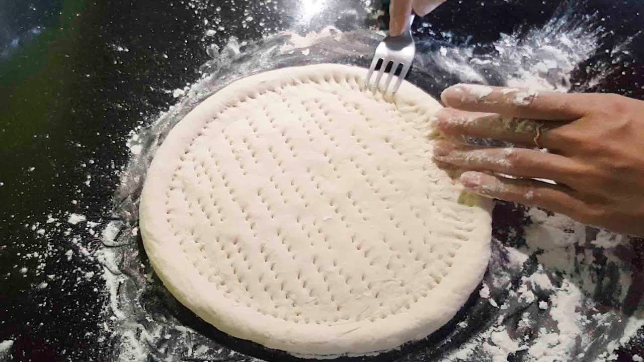 Xăm lỗ trên mặt bột trước khi nướng bánh pizza
