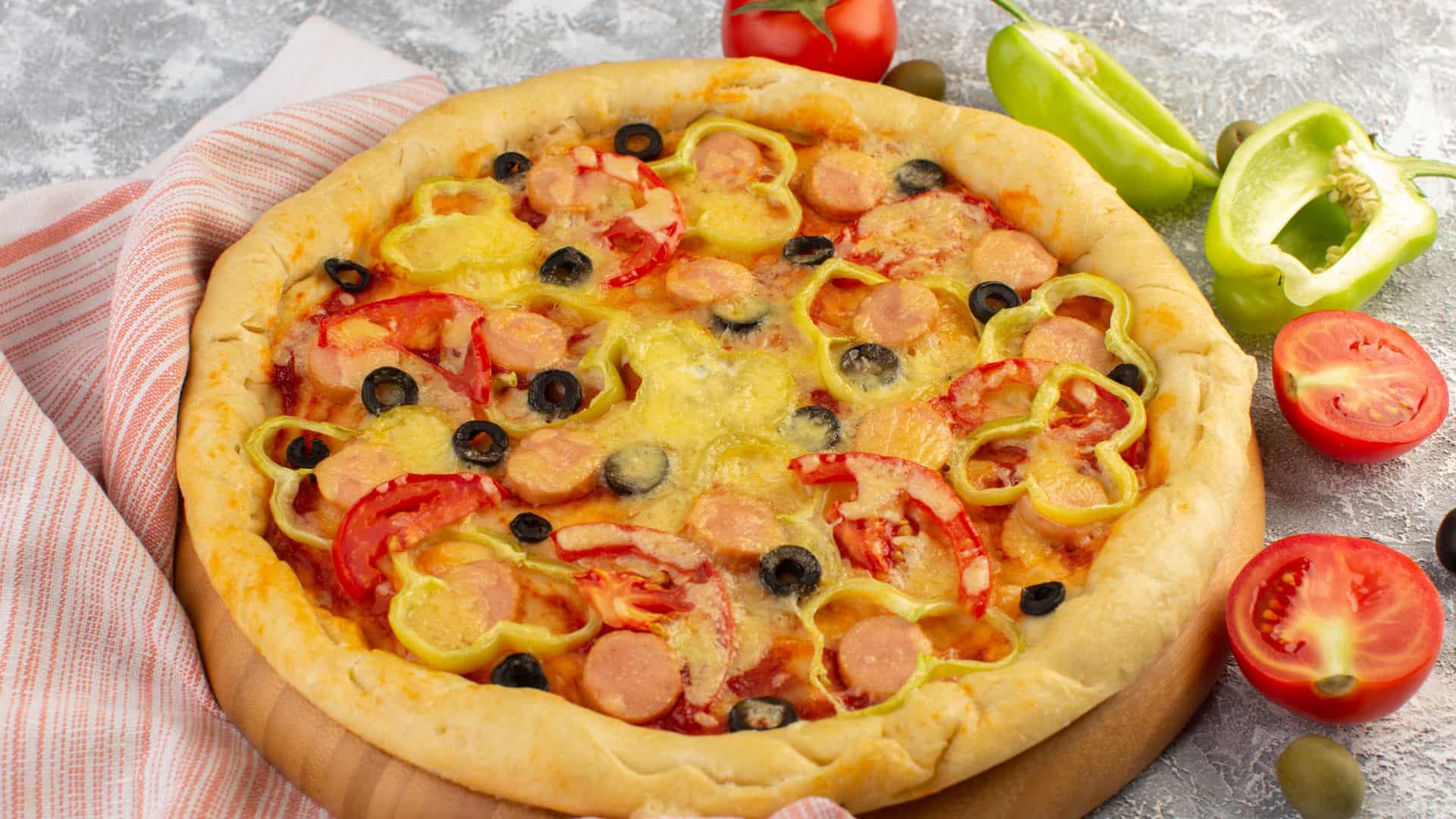 Pizza xúc xích kết hợp rau củ nhiều màu sắc như cà chua cherry, ớt chuông, nấm và hành tây, tạo nên món ăn hấp dẫn, dễ ăn cho bé.