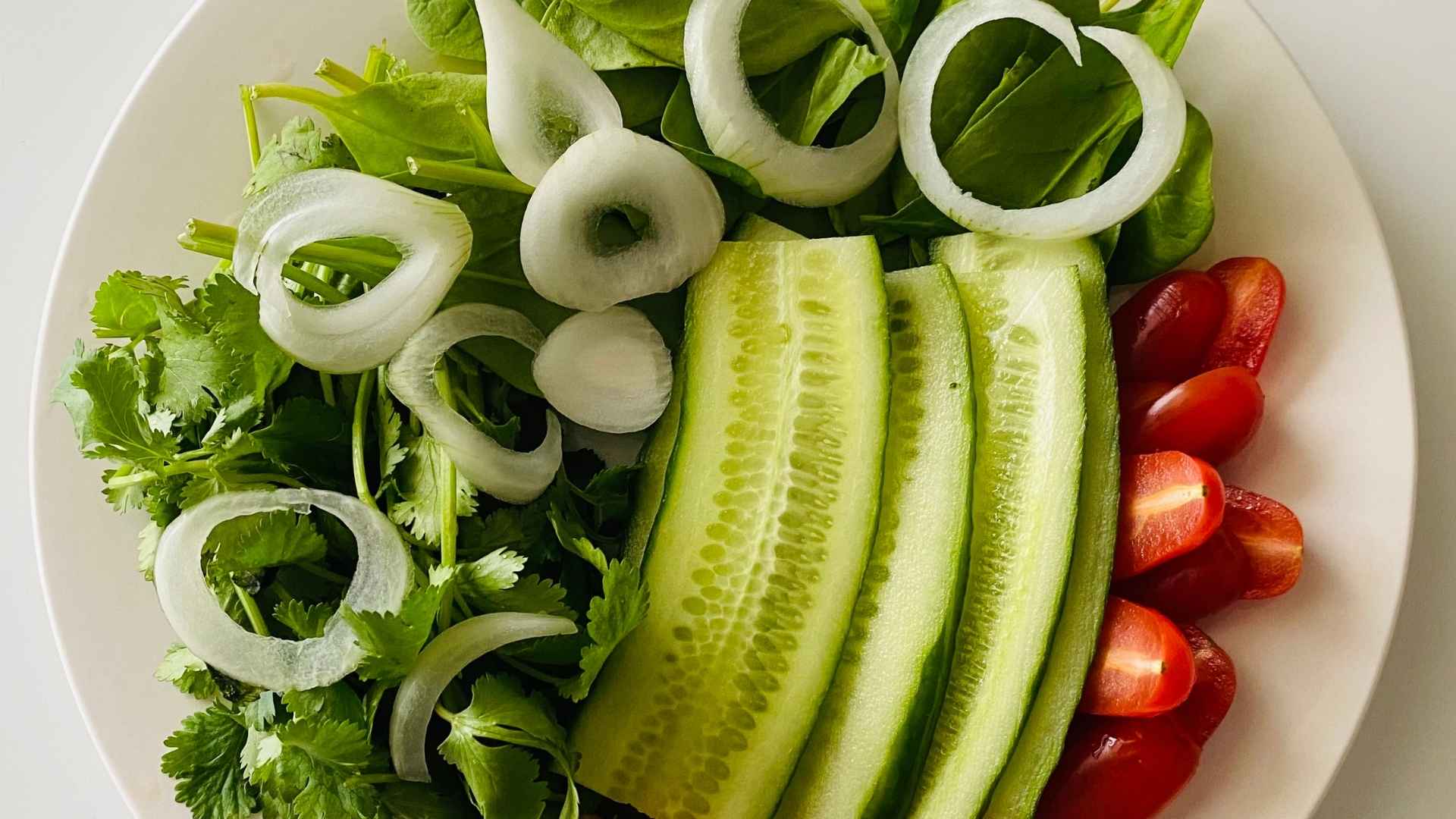 Xà lách, cà chua, dưa leo, ớt chuông và hành tây được chuẩn bị cùng các nguyên liệu pha xốt dầu giấm.