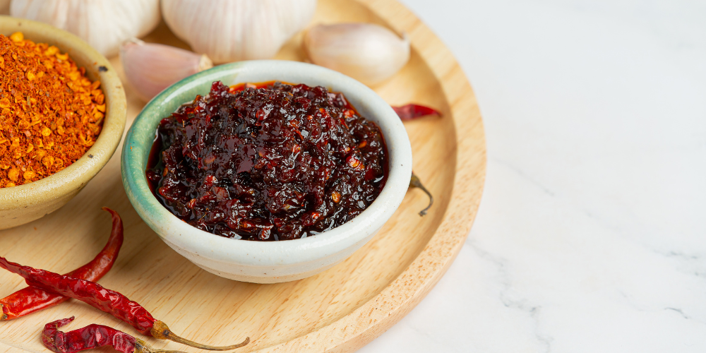 Bạn cho sa tế, nước mắm, đường, tiêu, bột ớt, dầu ăn, dầu điều, tỏi và hành băm vào tô trộn đều