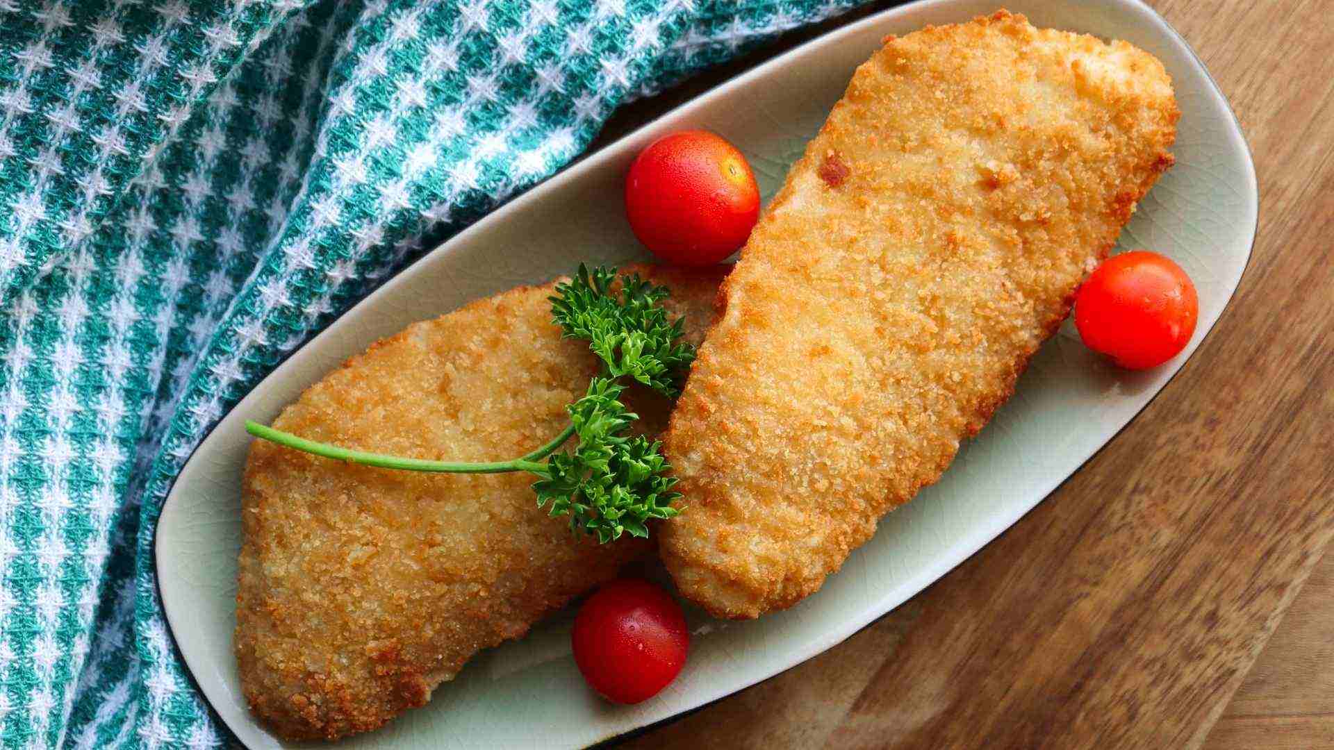 Cá tẩm bột chiên giòn được để ráo trên vỉ và dùng khi còn ấm để giữ kết cấu tốt nhất.